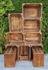 A stack of wooden crates arranged in a display against a green leafy background. Náhled obrázku produktu