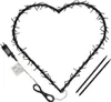 A heart-shaped string of lights with a power adapter and two stakes. Produktbild-Vorschau