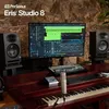 A recording studio setup with monitors, a computer screen displaying audio software, a keyboard, a microphone, and a piano. Voir les images du produit