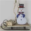 A decorative snowman on a sled with a gift. Produktbild-Vorschau