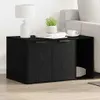 A black wooden cabinet with two doors and an open shelf, placed next to a sofa. A lamp, books, and a cup of coffee are on top of the cabinet. Produktbild-Vorschau
