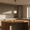 A modern kitchen island with a pendant light hanging above it. Náhled obrázku produktu