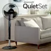 A Honeywell stand fan is placed next to a gray sofa in a living room. Produktbild-Vorschau