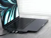 A close-up shot of a laptop with a docking station attached to its side, showing various ports and connected devices. Produktbild-Vorschau