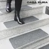 A person wearing black boots walks down a set of stairs covered with gray stair mats. Produktbild-Vorschau