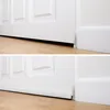 A close-up view of a white door and its baseboard, showing two different door bottom seals. Anteprima dell’immagine prodotto