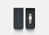A Daniel Wellington watch is presented in its dark blue packaging, with the watch case open and the watch inside. Voir les images du produit