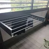 A wall-mounted drying rack with clothes hanging on it, situated on a balcony. Náhled obrázku produktu