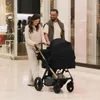 A couple pushing a stroller in a shopping mall. Voir les images du produit
