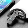 A close-up shot of a black Bluetooth headset with a digital display, placed on a textured surface next to a smartphone and a laptop. Produktbild-Vorschau