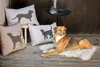 A dog is lying on a fluffy rug on a wooden deck, surrounded by decorative pillows with animal silhouettes. Produktbild-Vorschau