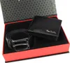 A gift set containing a black leather belt and a black leather wallet, presented in a red and black gift box. Voir les images du produit