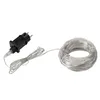 A black power adapter and a coiled string of white lights on a white background. Náhled obrázku produktu