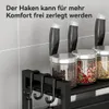 A close-up view of a black kitchen organizer with spice jars and knives on a tiled wall background. Produktbild-Vorschau