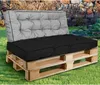 A pallet sofa with gray and black cushions sits on a grassy lawn in front of a stone wall. Náhľad obrázku produktu