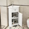 A white corner bathroom cabinet with a sink and faucet, filled with various toiletries. Náhled obrázku produktu