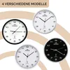 Four different models of MONZANA® wall clocks are displayed in a collage against a light brown and white background. Anteprima dell’immagine prodotto