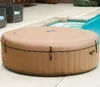 An inflatable hot tub covered with a tan lid, situated on a patio next to a swimming pool. Náhľad obrázku produktu