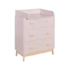 A pink changing table with wooden accents and three drawers, shown against a white background. Podgląd zdjęcia produktu