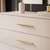 Close-up of a beige dresser with gold handles. Produktbild-Vorschau