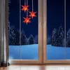 Three red star-shaped LED lights hanging in front of a window overlooking a snowy forest at night. Anteprima dell’immagine prodotto