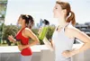 Two women jogging outdoors, one holding a green smoothie in a shaker bottle. Anteprima dell’immagine prodotto