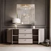 A dresser with drawers and doors, a lamp, and a mirror in a room. Produktbild-Vorschau
