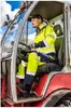 A man wearing high-visibility workwear is sitting in the driver's seat of a tractor. Náhled obrázku produktu