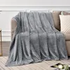 A gray blanket is draped over a sofa, with a pillow on the right side. Produktbild-Vorschau