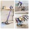 A collage of three images showing a cordless vacuum cleaner in different settings: cleaning a carpet, mounted on a wall, and near a tablet. Produktbild-Vorschau