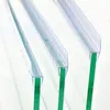 Three clear plastic shower door seals are shown attached to the edges of three green glass shower doors. Podgląd zdjęcia produktu