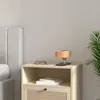 A bedside table with a lamp, glasses, and books. Produktbild-Vorschau