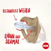 A close-up marketing image of a NUK pacifier, highlighting its features with text overlays and arrows. Voir les images du produit