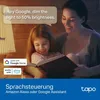 A mother and daughter reading a book in a dimly lit room, with a smart light bulb being controlled by voice commands. Produktbild-Vorschau