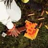 A person's hands are holding a toy axe and blaster on a grassy lawn. Podgląd zdjęcia produktu