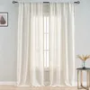 A pair of sheer, beige curtains with decorative trim hangs in front of a window. A small side table with a vase of dried flowers is visible to the right. Produktbild-Vorschau