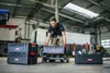 A man in a workshop is moving toolboxes. Náhled obrázku produktu