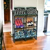 A metal shelving unit holding crates of drinks and produce in a room with wooden floors. Produktbild-Vorschau