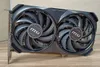 A computer graphics card with two fans is shown on a wooden surface. Produktbild-Vorschau