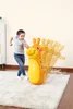 A young girl is playing with an inflatable giraffe bop bag in a room. Produktbild-Vorschau