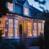 A house decorated with string lights at dusk. Anteprima dell’immagine prodotto