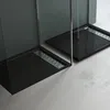 Two modern black shower trays with chrome drains are shown in a minimalist bathroom setting. Produktbild-Vorschau