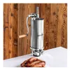 A stainless steel sausage stuffer is shown in front of a wooden background, with a pile of sausages in the foreground. Náhľad obrázku produktu