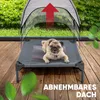 A pug dog is lying on a raised dog bed with a canopy, outdoors on a wooden deck. Produktbild-Vorschau