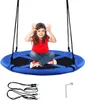 A young girl sits on a blue round swing, making a playful gesture with her hands. Voir les images du produit
