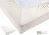 A close-up view of a cream-colored jersey fitted sheet on a mattress, with a smaller stack of fitted sheets in the bottom left corner. Produktbild-Vorschau