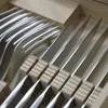 A close-up view of a set of steak knives and forks stored in a wooden cutlery organizer. Produktbild-Vorschau