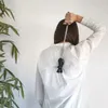 A person scratching their back with a cat-shaped back scratcher. Náhled obrázku produktu