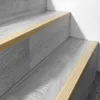 Close-up view of beige stair nosing strips on gray laminate flooring on a staircase. Anteprima dell’immagine prodotto