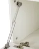 Close-up view of a gas strut and hinges inside a white cabinet. Anteprima dell’immagine prodotto